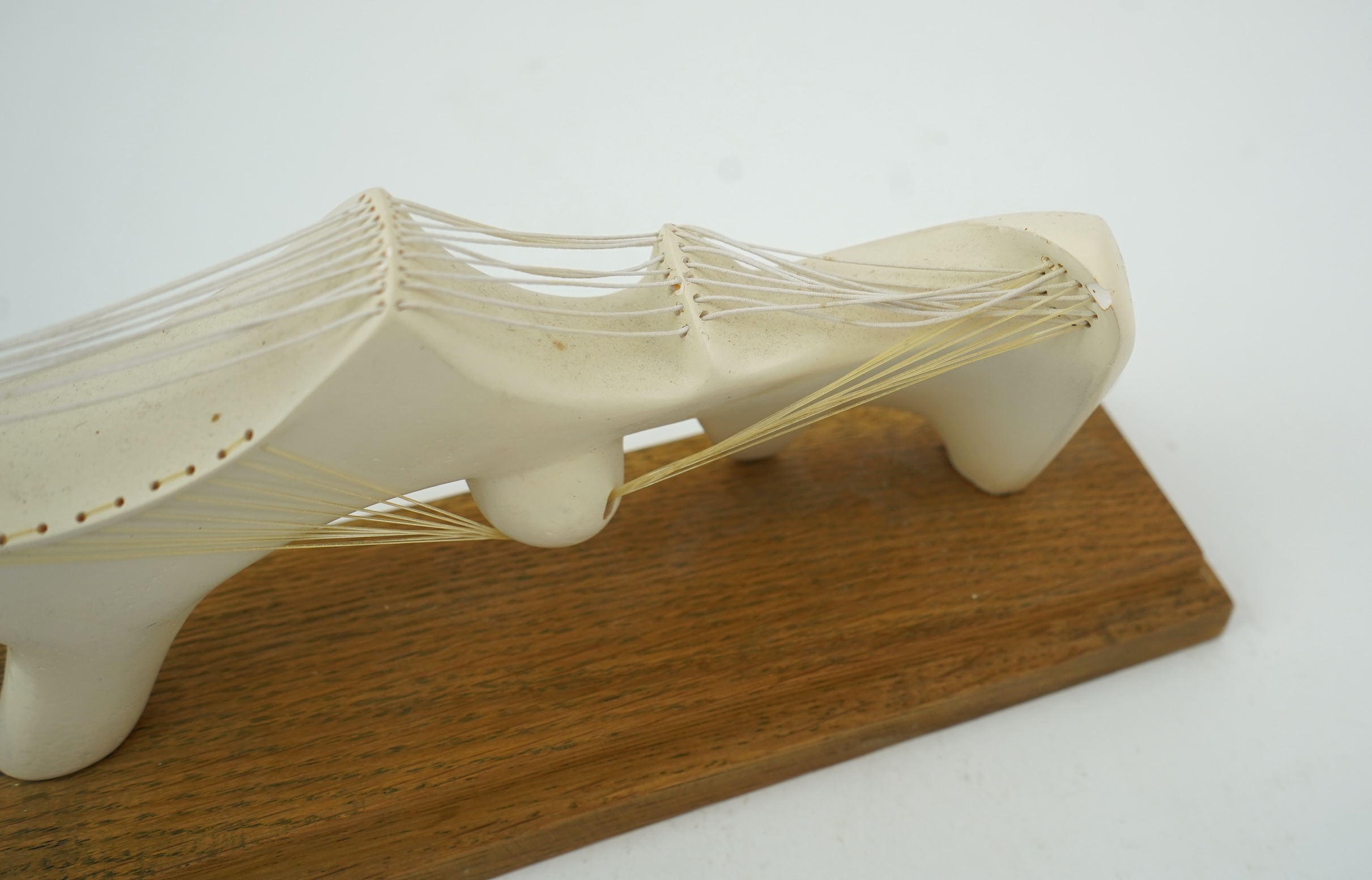 Follower of Henry Moore (1898-1986) A modernist stringed plaster sculpture raised on an oak rectangular plinth base, 25cm wide